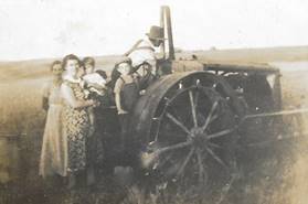 A group of people standing around a tractor

Description automatically generated with low confidence