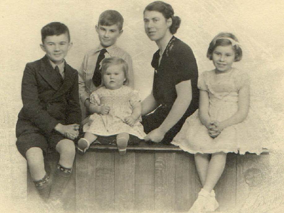 A vintage photo of a group of people posing for the camera

Description automatically generated