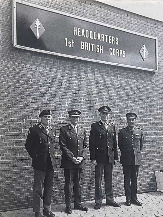 A group of men standing in front of a brick building

Description automatically generated with medium confidence