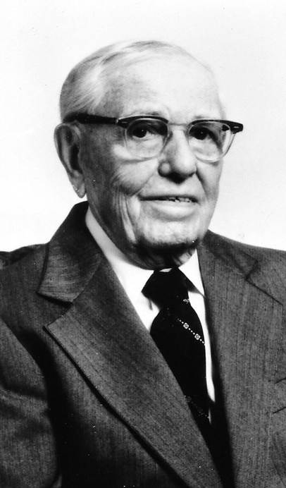 A vintage photo of a person in a suit and tie

Description automatically generated