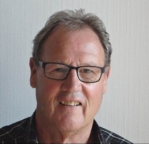 A person wearing glasses and smiling

Description automatically generated