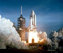 A rocket taking off from a launch pad
Description automatically generated