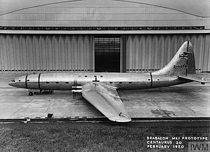 An airplane parked in front of a hangar

Description automatically generated