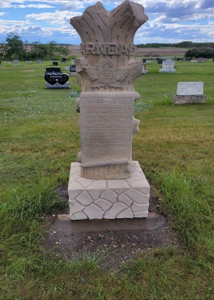 A stone monument in a cemetery
Description automatically generated