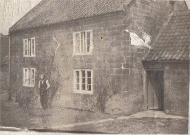 A person standing in front of a house
Description automatically generated