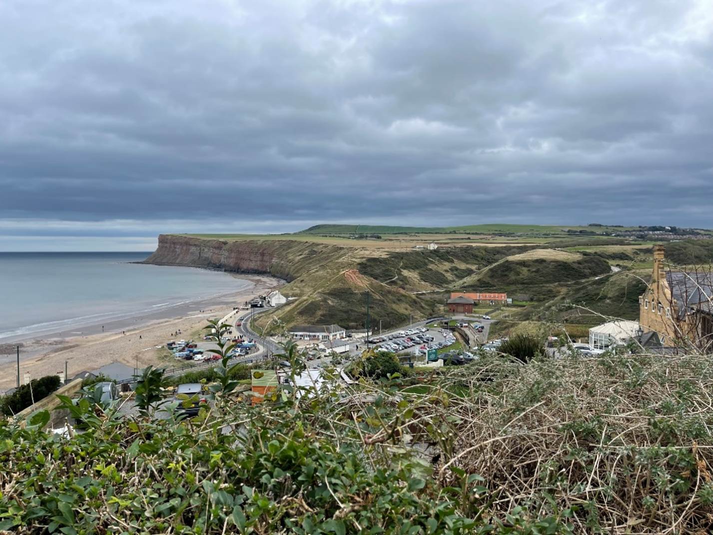 A landscape with a beach and a body of water
Description automatically generated