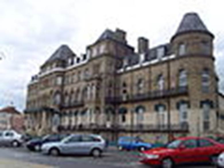 A building with cars parked in front of it
Description automatically generated