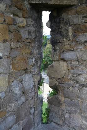 A stone wall with a hole in the wall
Description automatically generated