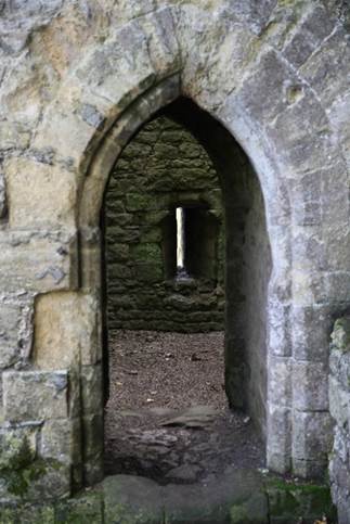 A stone wall with a hole in it
Description automatically generated