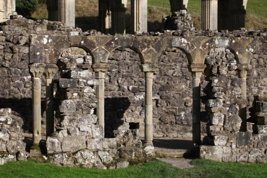 A stone wall with columns
Description automatically generated