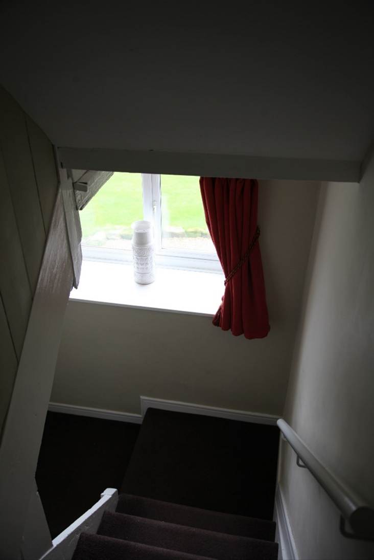 A red curtain on a window sill
Description automatically generated