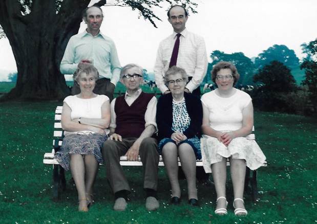 A group of people sitting on a bench
Description automatically generated