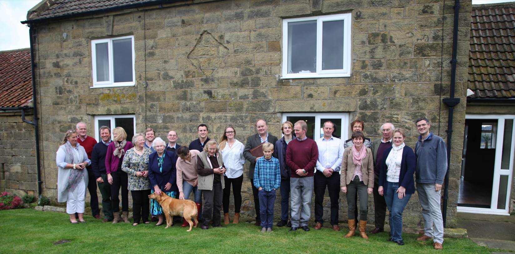 A group of people standing in front of a building
Description automatically generated