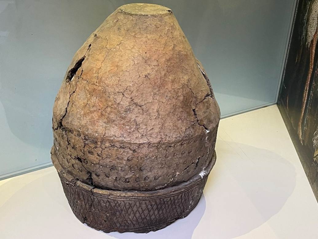 A large stone pot on a white surface
Description automatically generated
